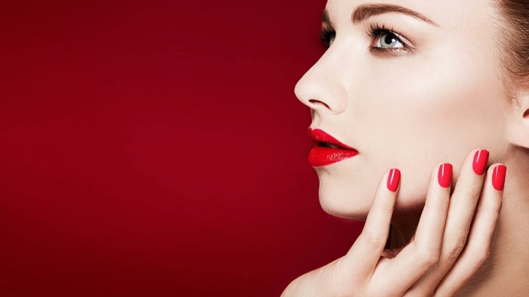 unghie laccate di rosso della stessa nuance del rossetto per una combinazione sexy ed elegante